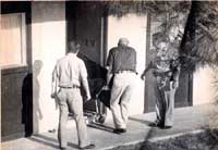 Police investigators remove crane's body from his Scottsdale apartment.